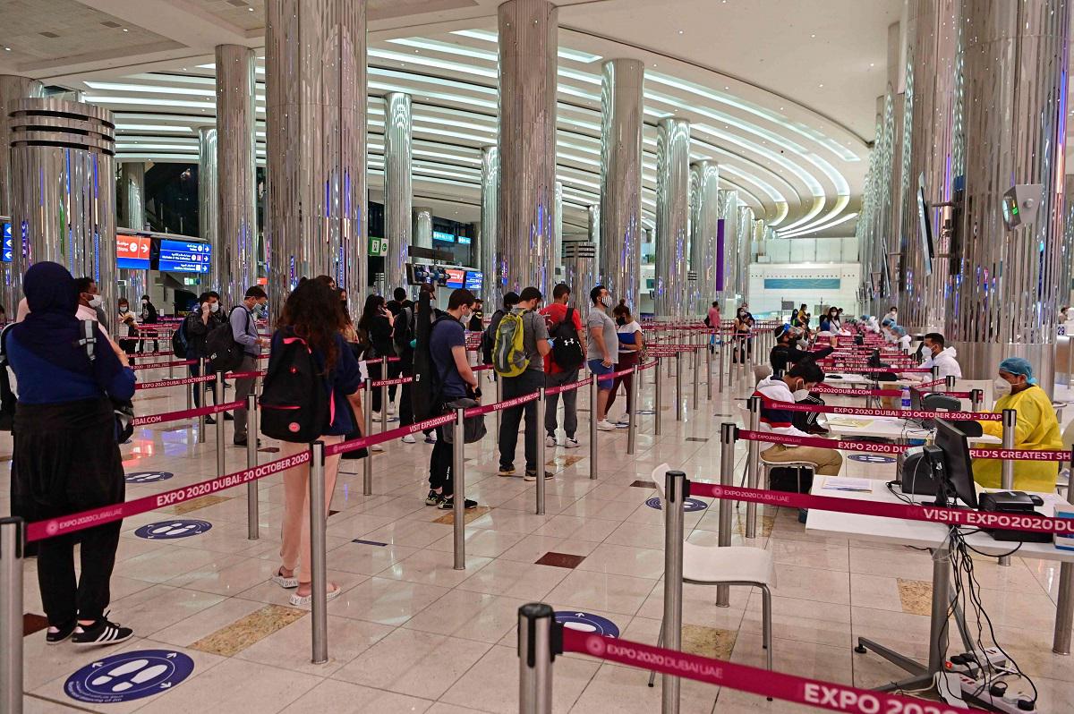  سياح يصطفون في طابور للحصول على فحص طبي عند وصولهم إلى مطار دبي