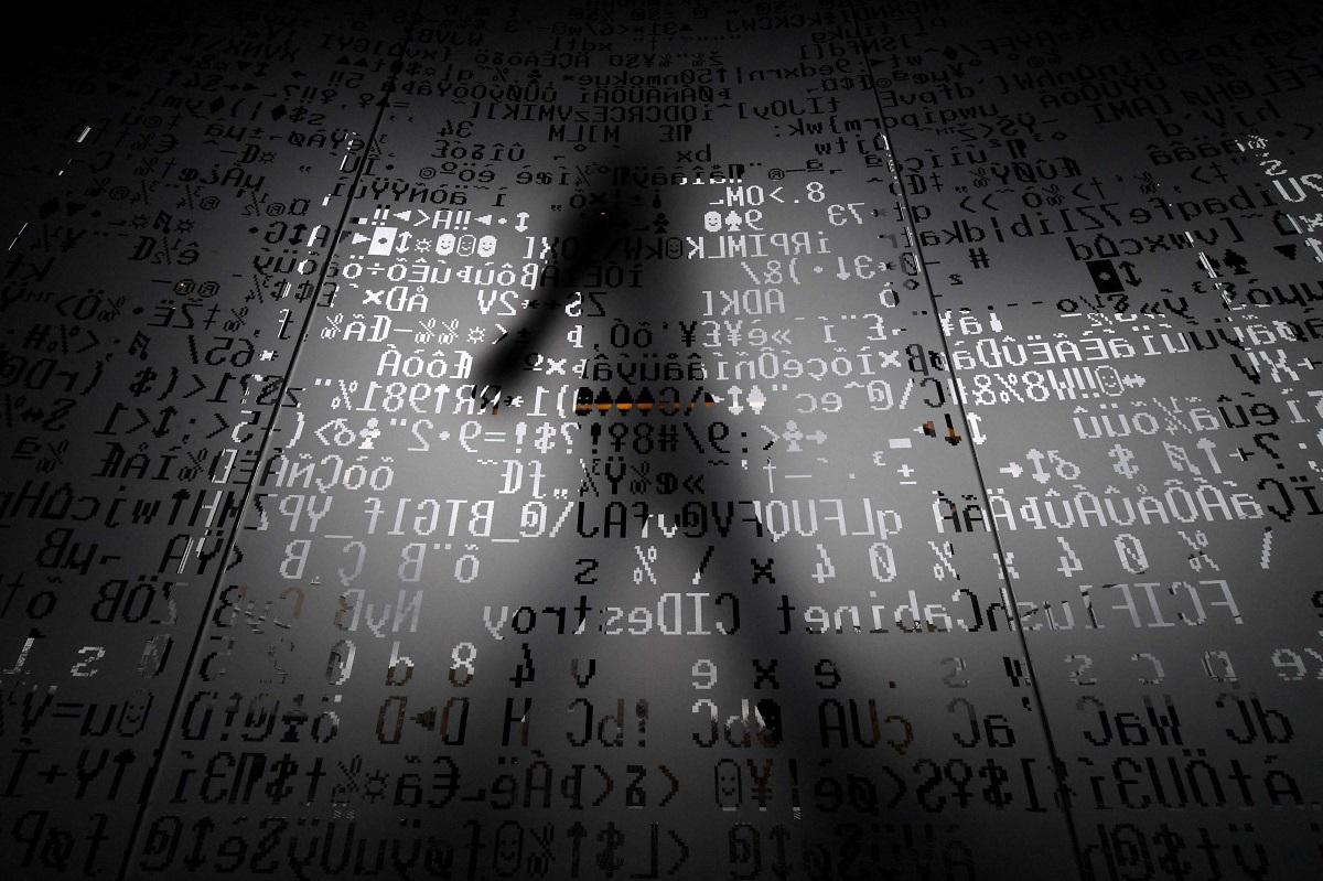موظف يسير خلف جدار زجاجي عليه ترميز آلي في مقر شركة أمن الإنترنت العملاقة كاسبرسكي في موسكو