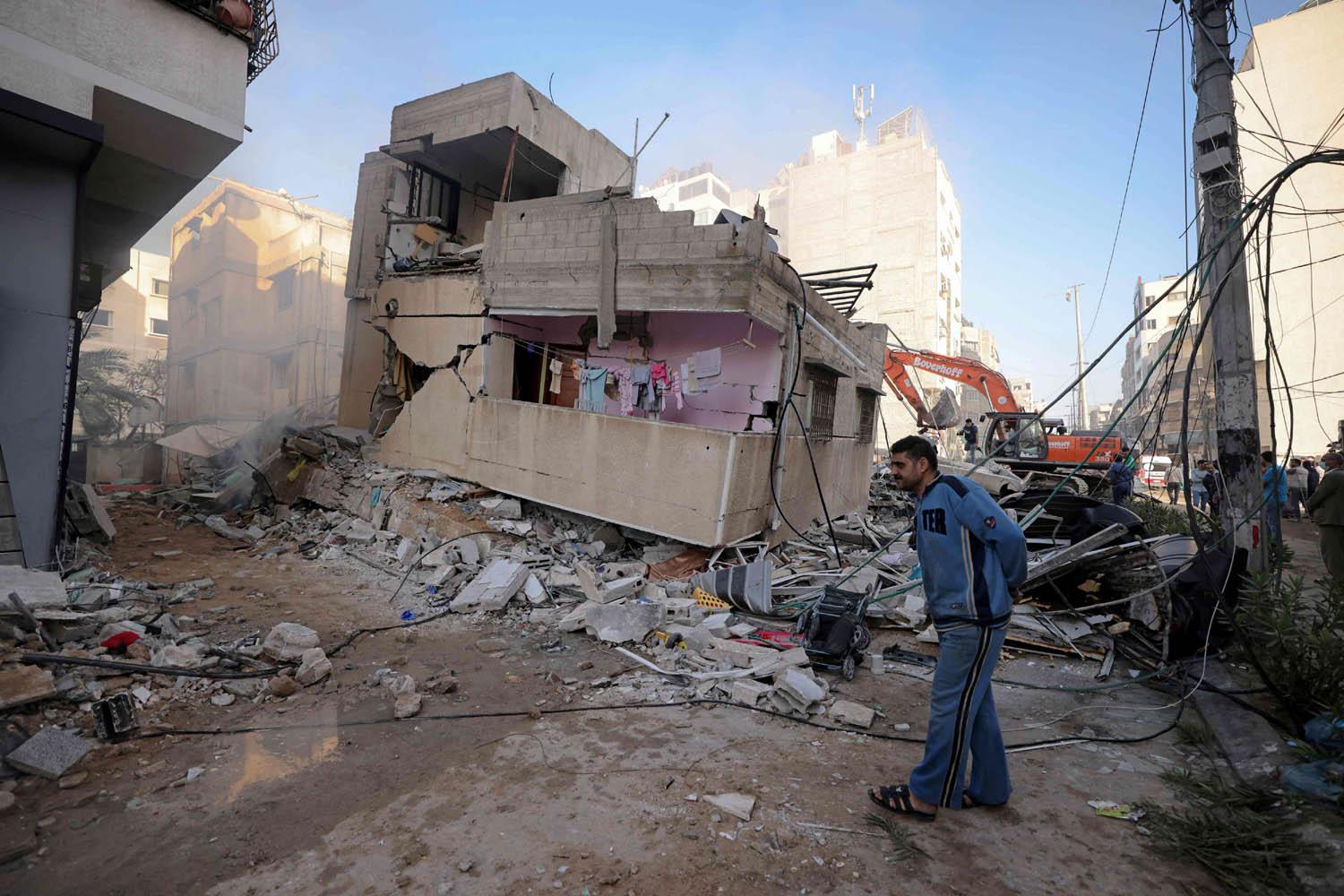 فلسطيني يقف بجانب منزل تم تدميره في غراة اسرائيلية في غزة