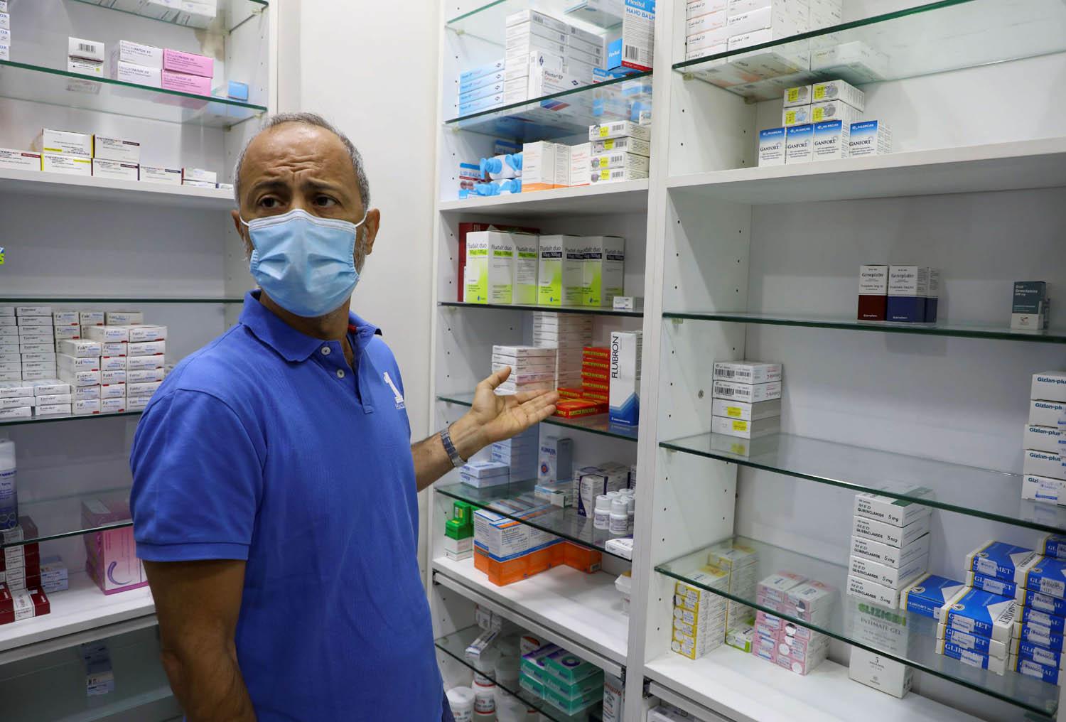 صيدلي لبناني يستعرض نقص الدواء في صيدلية في بيروت