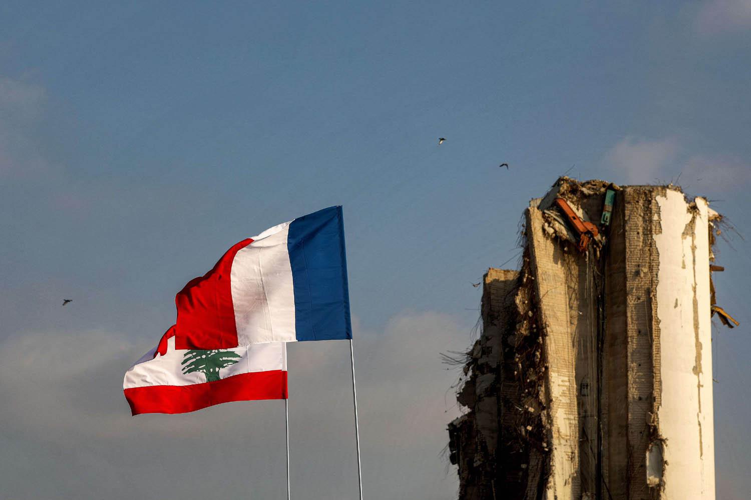 علمان لبناني وفرنسي بالقرب من صوامع الحبوب المدمرة في مرفأ بيروت