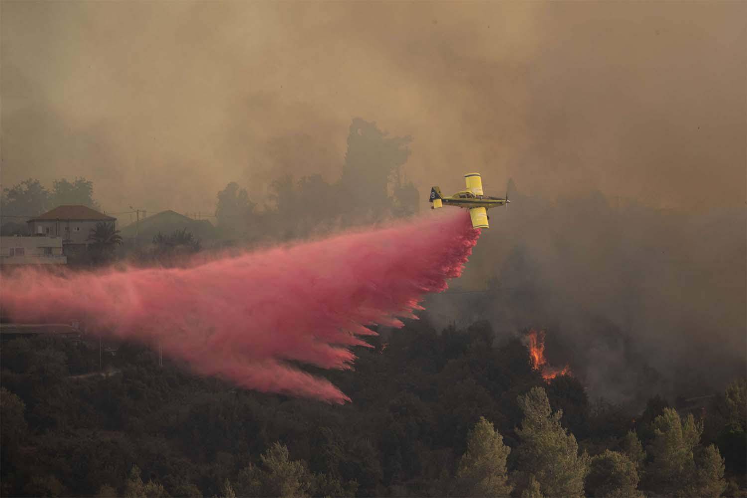 A plane sprays wildfires burning for for the second day near Shoresh, on the outskirts of Jerusalem