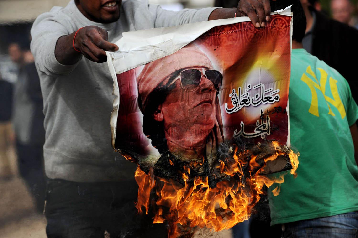 ليبي يحرق صورة للقذافي في بنغازي