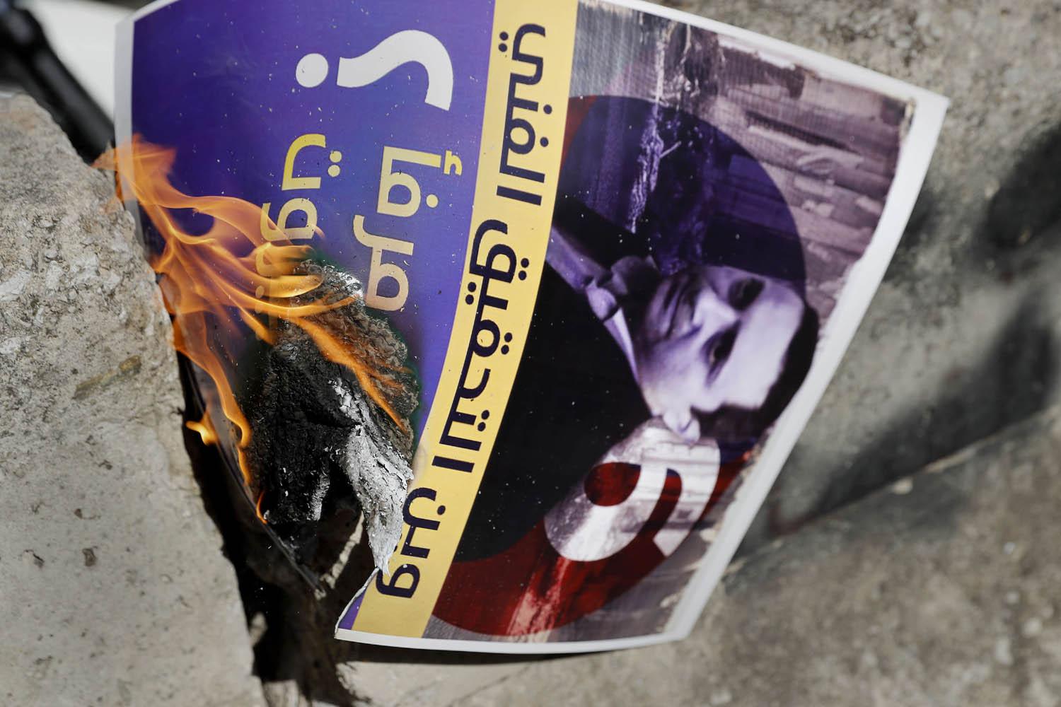 متظاهرون من حزب الله وأمل يحرقون بوستر لقاضي التحقيق طارق بيطار في بيروت