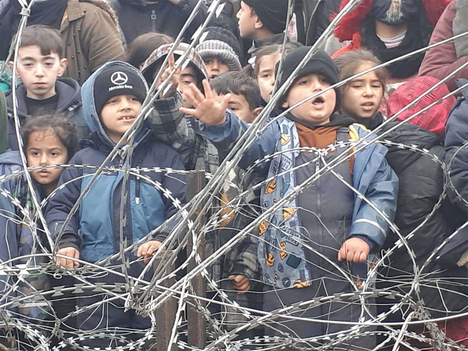 Migrants children gather near the fence on the Poland/Belarus border near Kuznica, Poland
