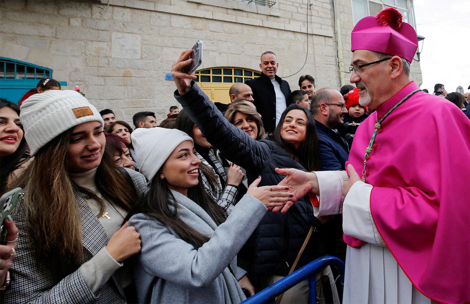 Pizzaballa greets people as he arrives to attend Christmas celebrations in Bethlehem