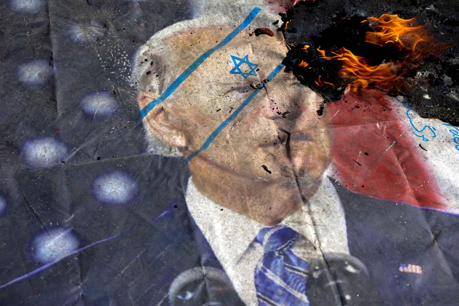 متظاهرون يدوسون ويحرقون صورة للرئيس الأميركي جو بايدن في طهران  