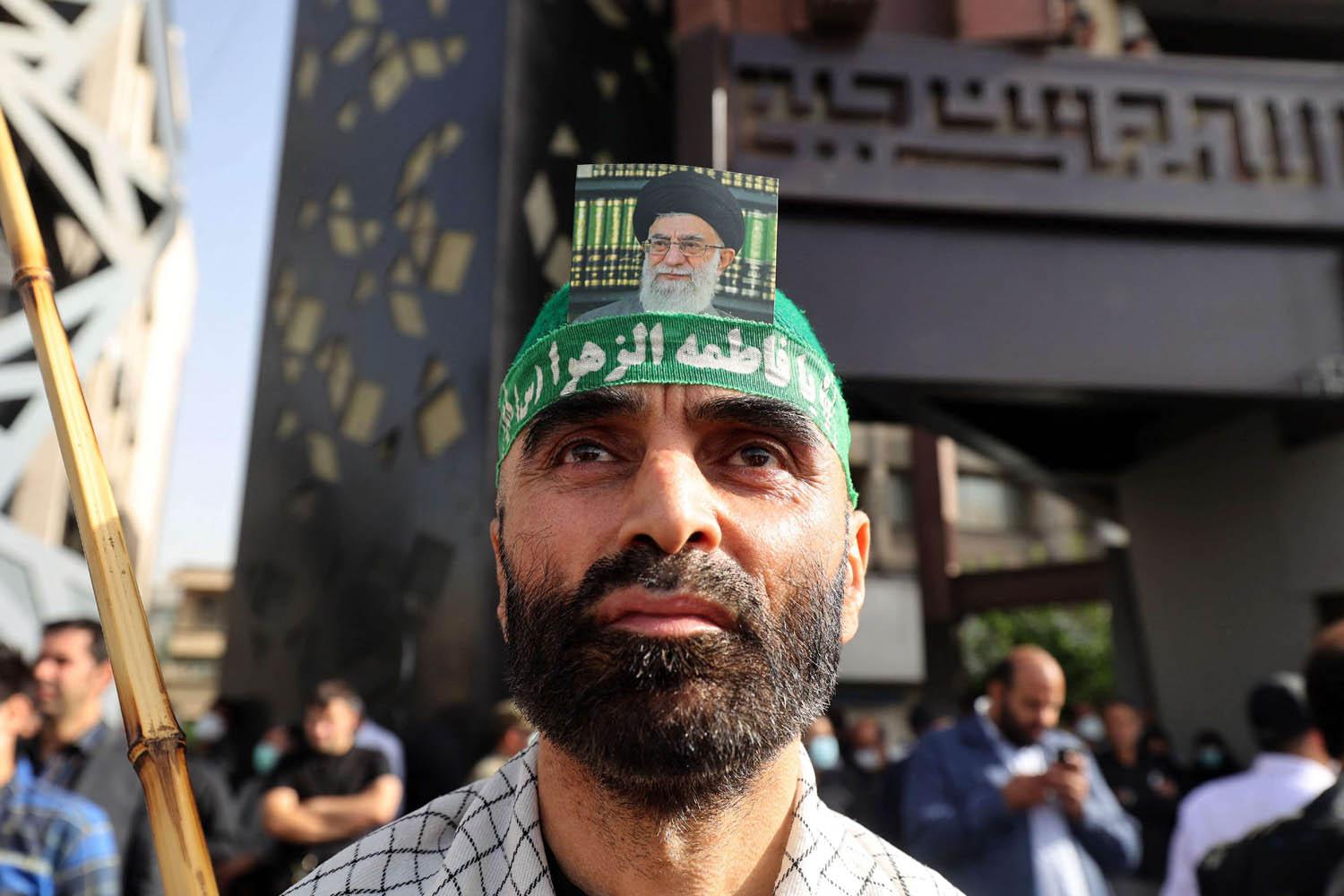 إيراني يضع صورة المرشد الأعلى علي خامنئي على رأسه