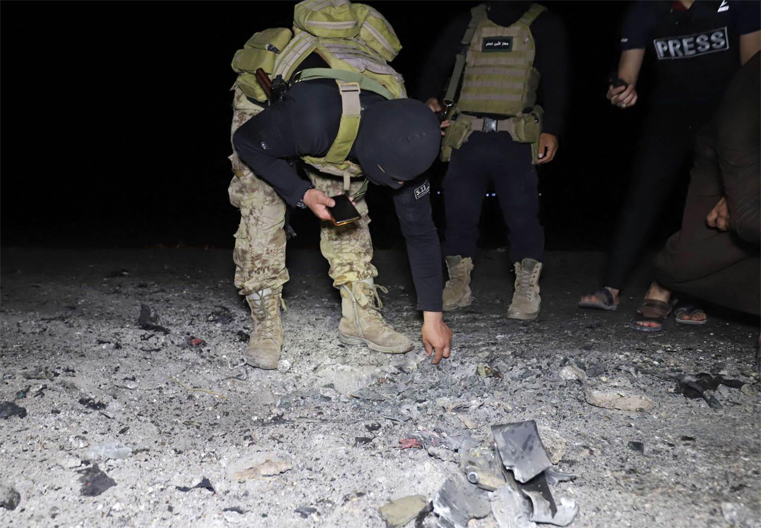 Fighters affiliated with the Hayat Tahrir al-Sham jihadist group in Syria inspect the site of a reported drone attack 