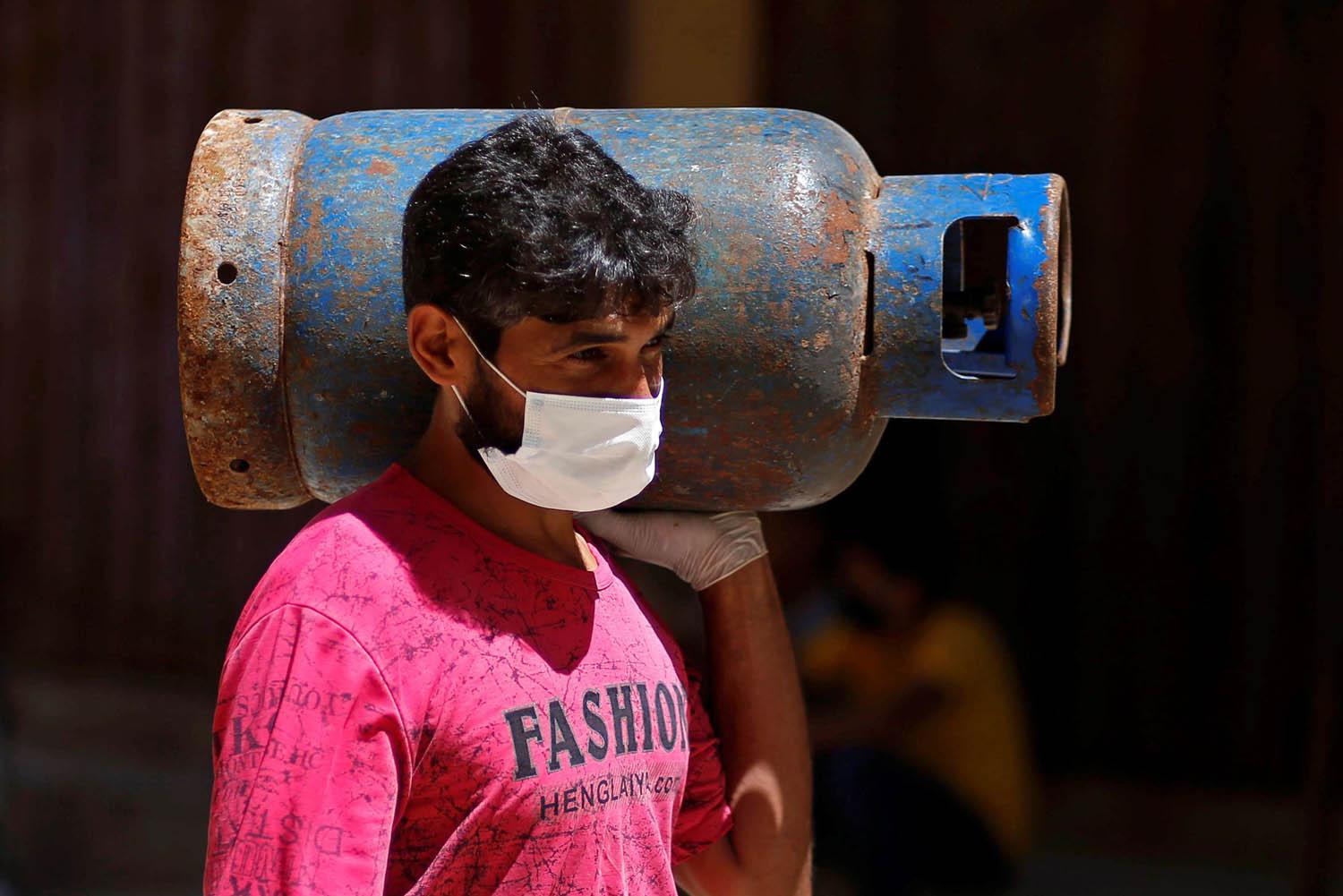 فلسطيني يحمل اسطوانة غاز في غزة