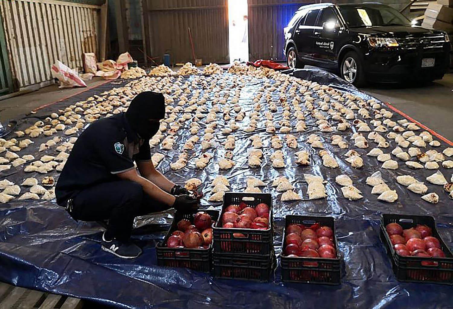 موظف في الجمارك السعودية يستعرض شحنة كبتاغون مهربة