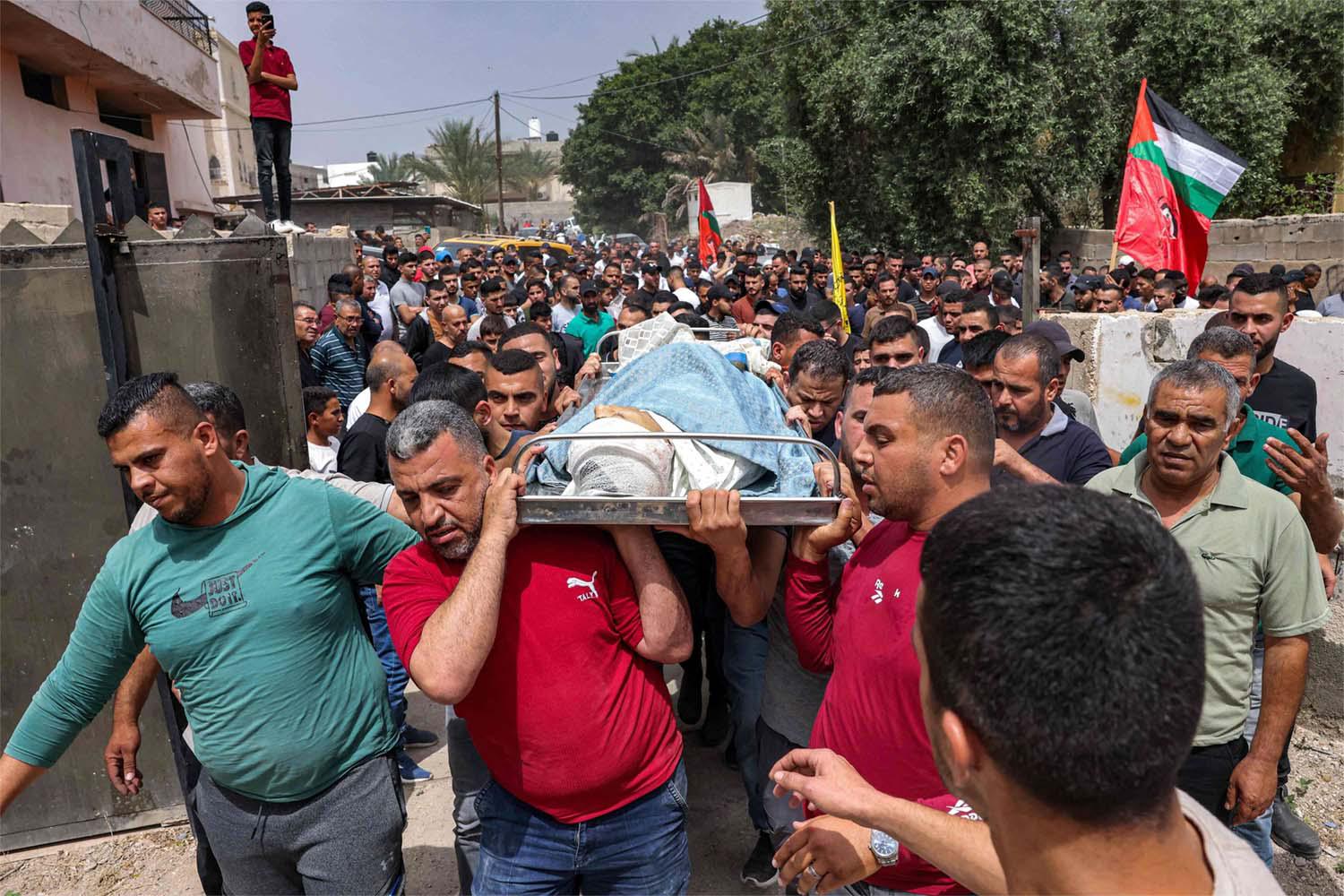 Mourners carry the body of Palestinian teenager Mohamed Fayez Balhan