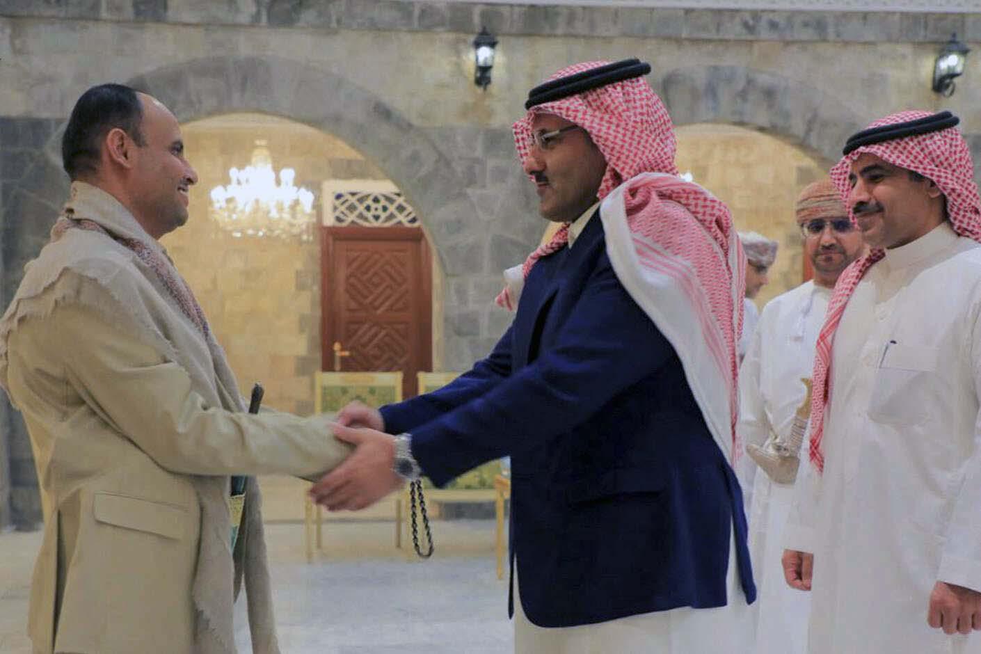 Houthis' political leader Mahdi al-Mashat (L) welcoming the Saudi ambassador to Yemen Mohammed Al Jaber