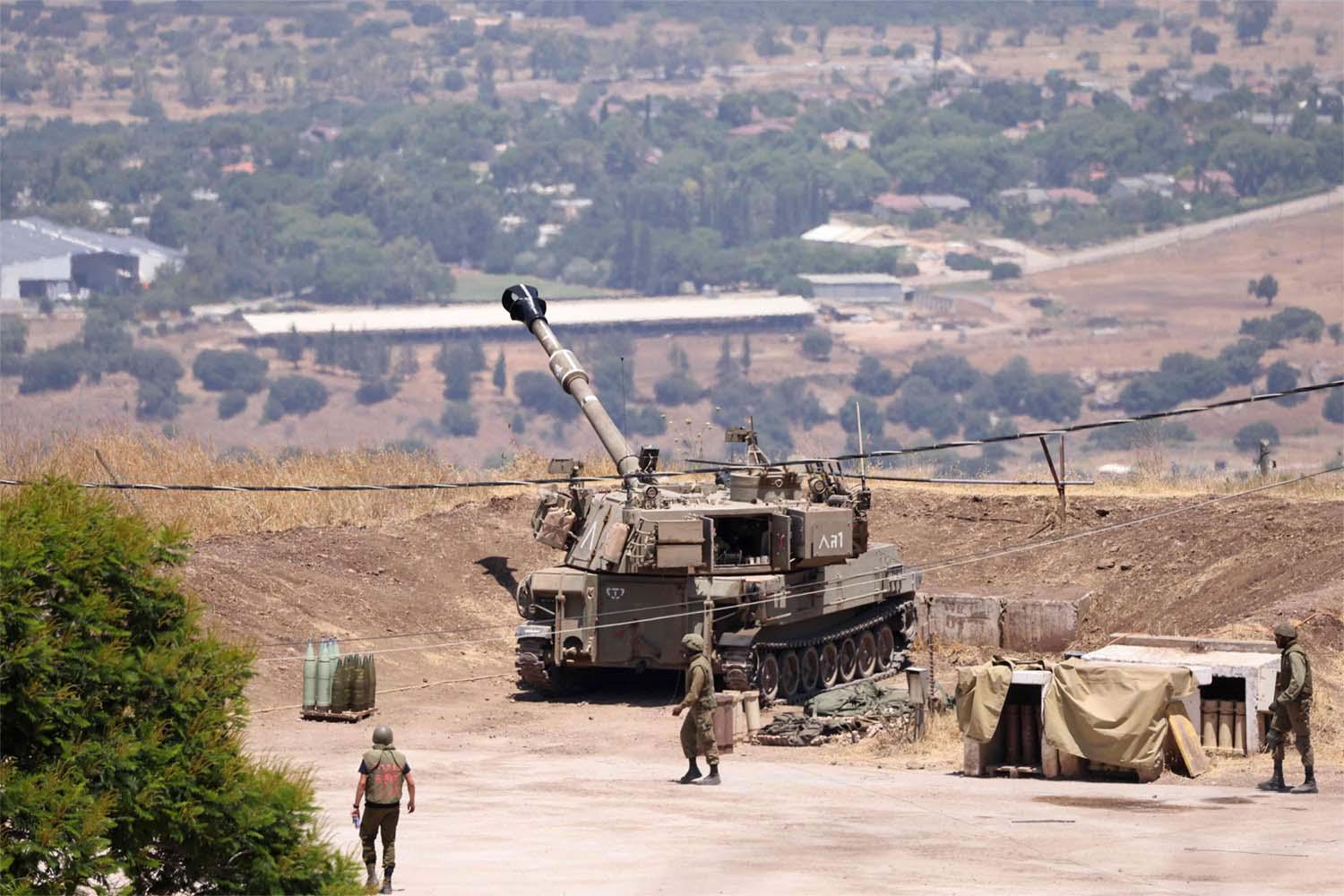 Israeli soldiers stand near an army tank on the outskirts of Kiryat Shmona near Israel's border with Lebanon