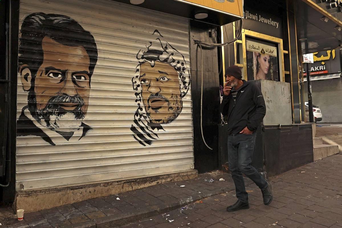تخطيطان للرئيس العراقي الراحل صدام حسين والرئيس الفلسطيني الراحل ياسر عرفات على واجهة دكان في رام الله