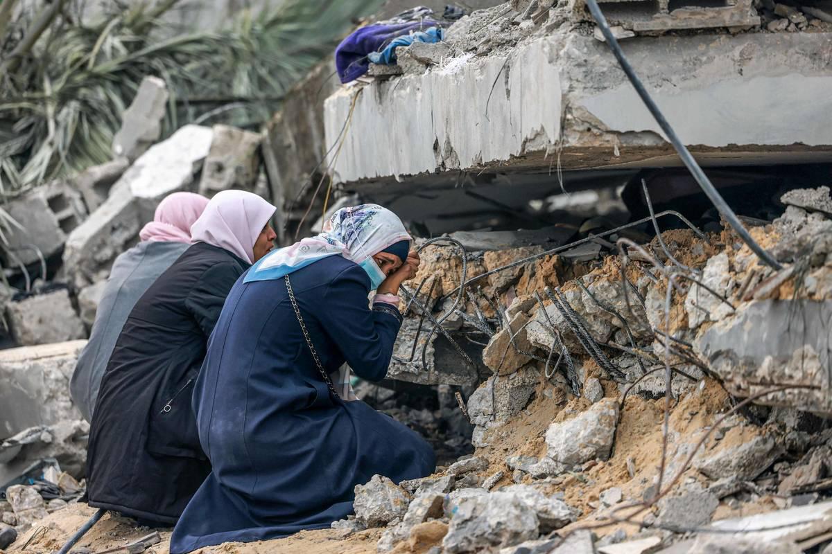 فلسطينيات أمام بيوتهن المدمرة في غزة