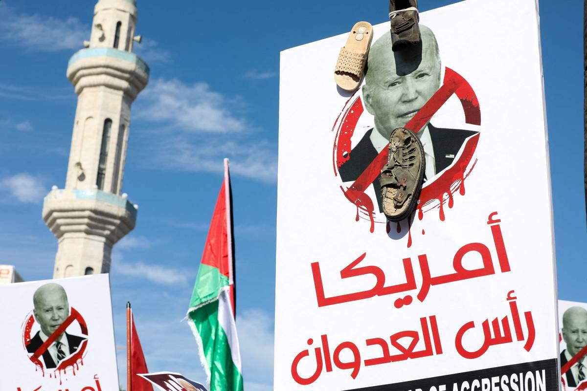 متظاهر أردني يرفع صورة تنتقد الرئيس الأميركي جو بايدن بسبب مساندته للحرب في غزة