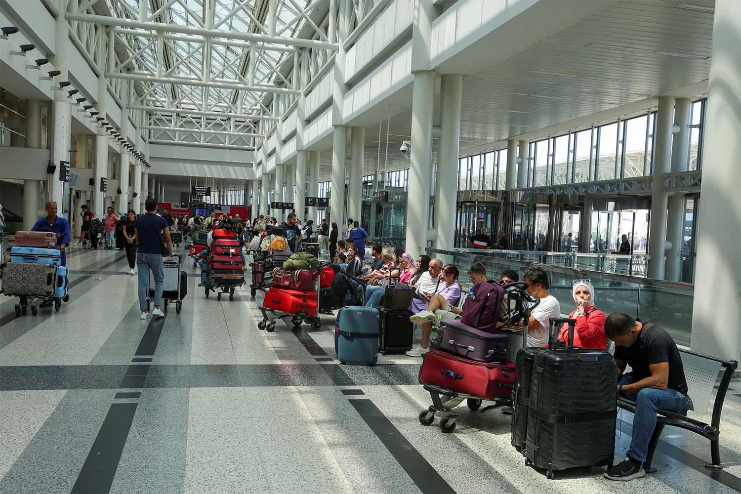 People wait with their luggage at Beirut-Rafiq Hariri International Airport