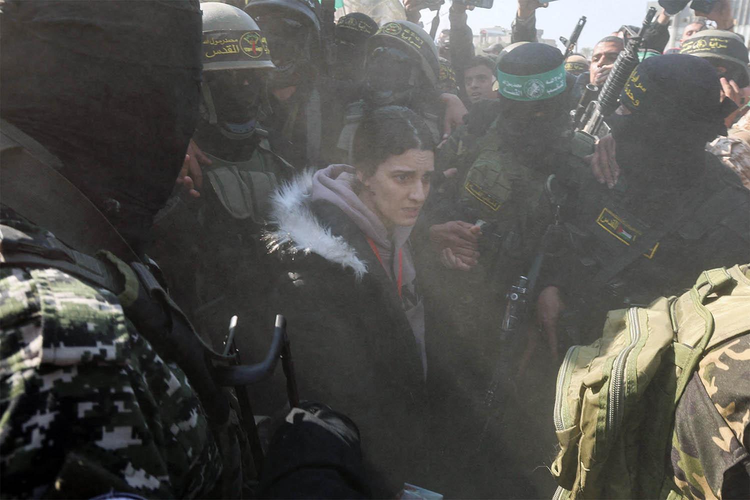 Palestinian militants surround hostage Arbel Yehoud during her handover to the ICRC