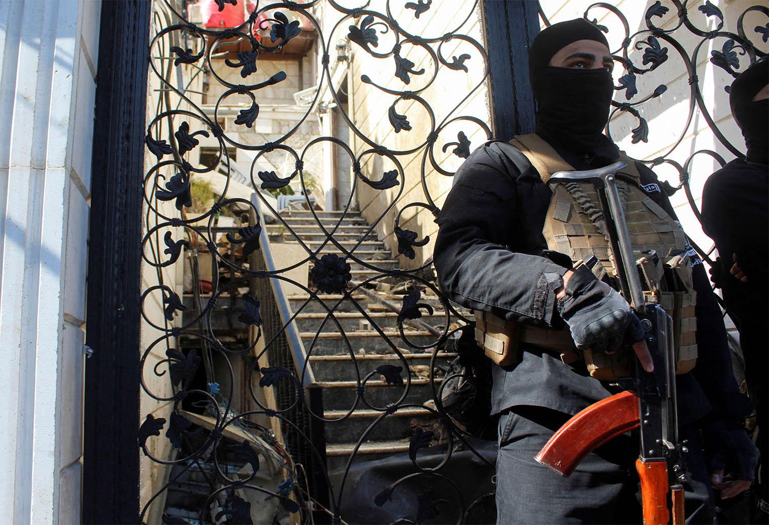 A member of Syrian security forces stands guard at a damaged site, after Israel carried out an air strike on Damascus