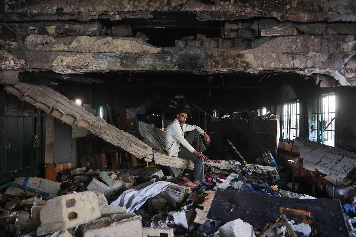 A man sits amid the debris at the Fahmi Al-Jarjawi School in Gaza City on May 26