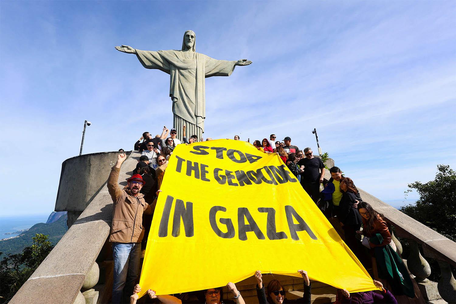 Activists hold a banner that reads Stop the genocide in Gaza during a protest to demand an immediate ceasefire in the region and the urgent entry of humanitarian aid for the Palestinians, at the Christ the Redeemer statue in Rio de Janeiro, Brazil June 14