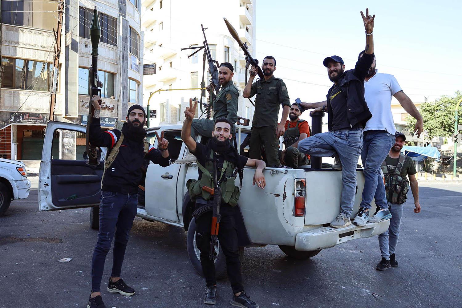 Syrian Druze fighters pose for a photograph after Syrian government forces pulled out of the Sweida governorate