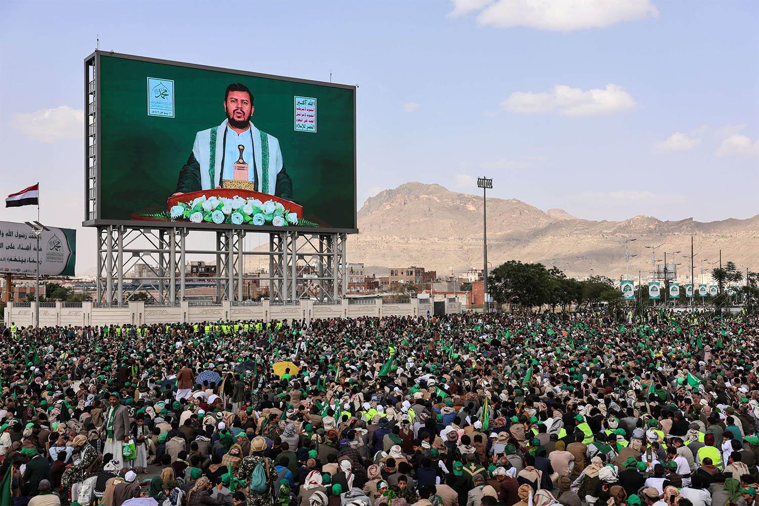 Abdul-Malik al-Houthi appears on a screen as people, mainly Houthi supporters, gather to mark the Prophet Muhammads birthday, at Sabeen Square in central Sanaa