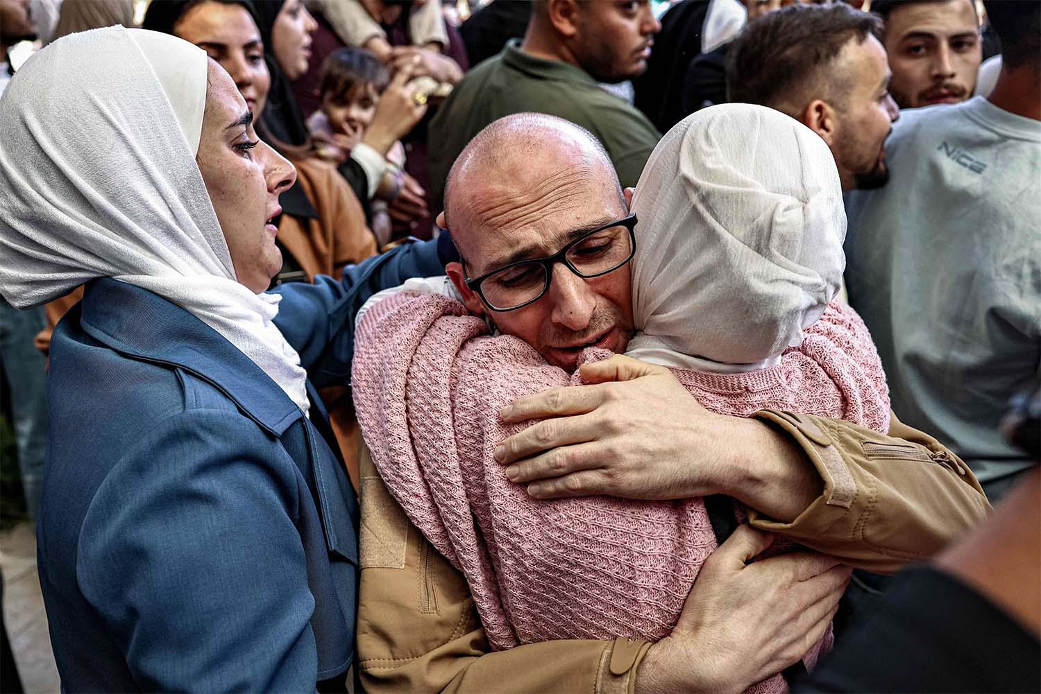 One of the Palestinian prisoners, who was released in a prisoner-hostage swap and ceasefire deal between Israel and Hamas, is embraced by a woman relative upon arrival by bus at Ramallah Cultural Centre in Ramallah