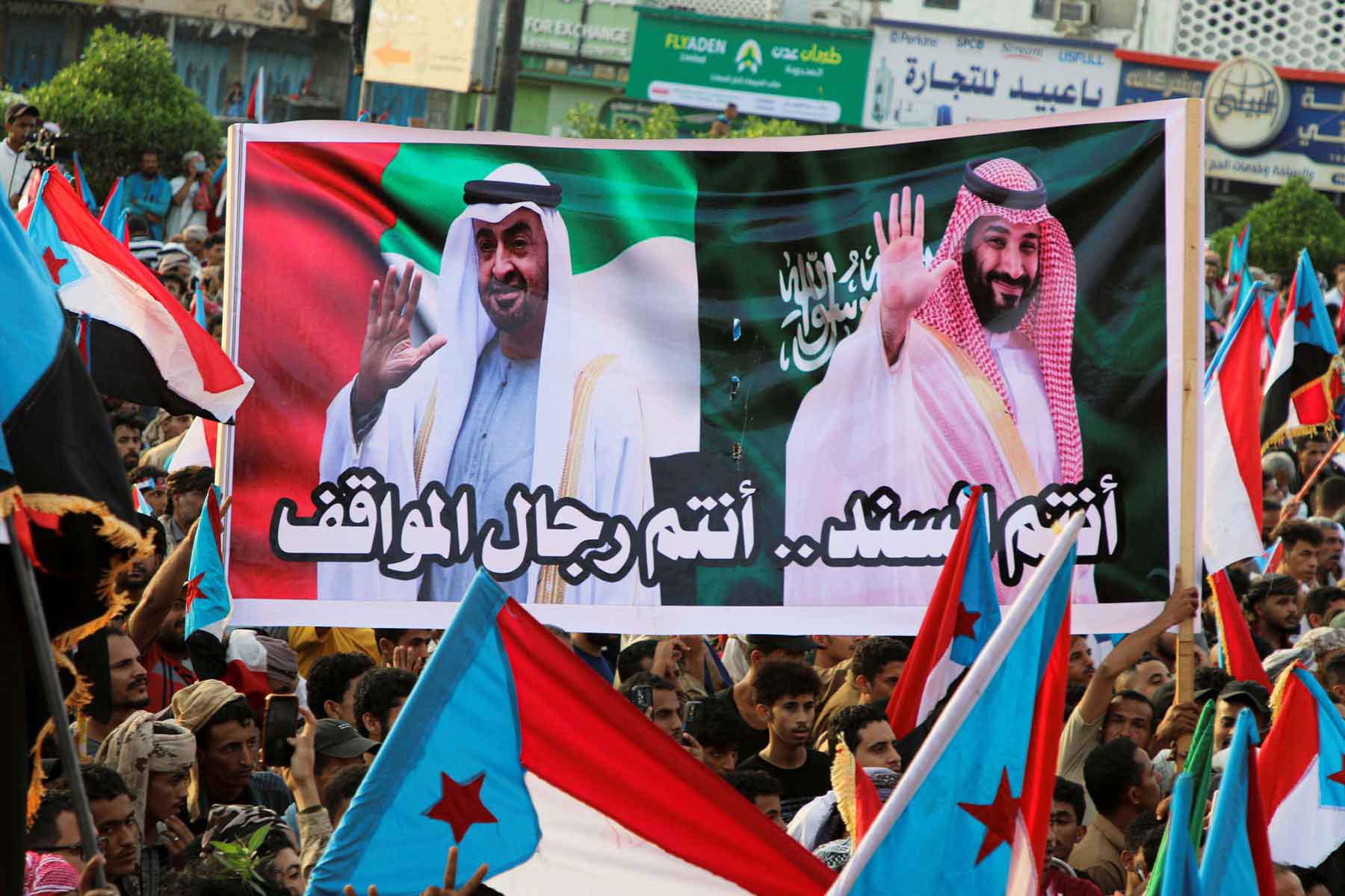 People hold a banner with images of the Emirati President Sheikh Mohamed bin Zayed Al Nahyan and Saudi Crown Prince Mohammed bin Salman during a rally organised by Yemen’s Southern Transitional Council in Aden, December 21, 2025. 