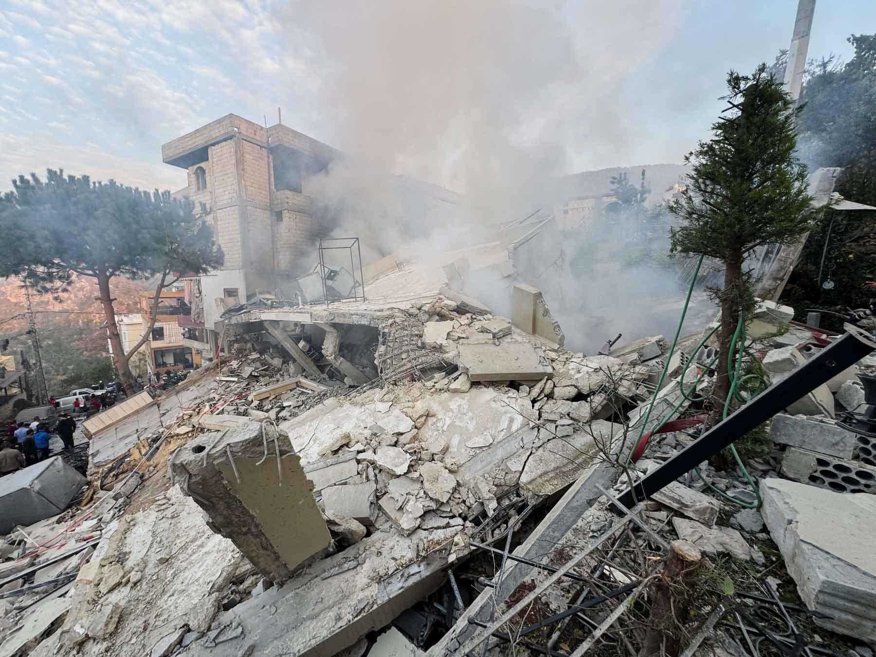 People inspect a damaged site after Israel’s military said it struck targets in two southern Lebanese towns, December 4, 2025. 