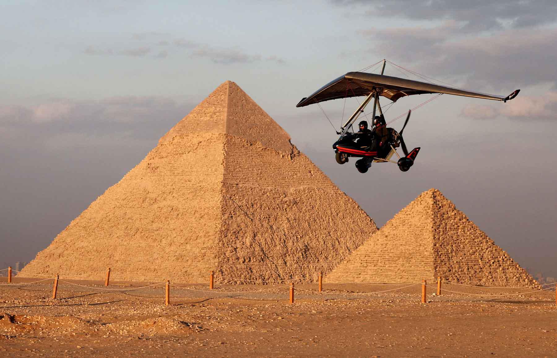 A tourist flies with an Ultralight trike pilot near the Great Pyramids of Giza, on the outskirts of Cairo.