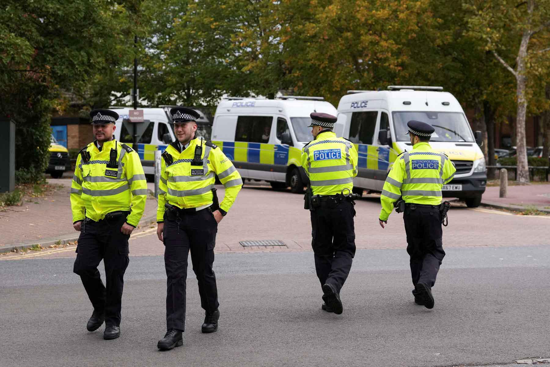 Police officers walk outside a court building in London.