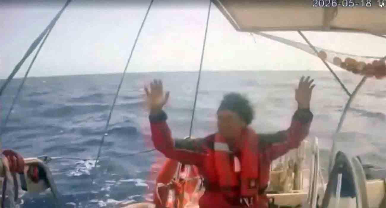 An activist raises his hand as an Israeli naval boat intercepts the Global Sumud Flotilla en route to Gaza, in an attempt to deliver aid, at sea
